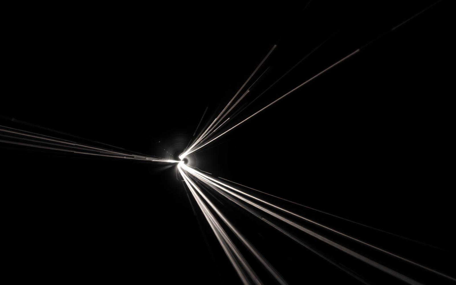 Long-exposure light streaks radiating through a dark tunnel